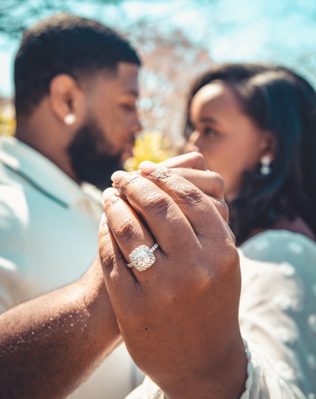 His hand over hers, the ring in focus