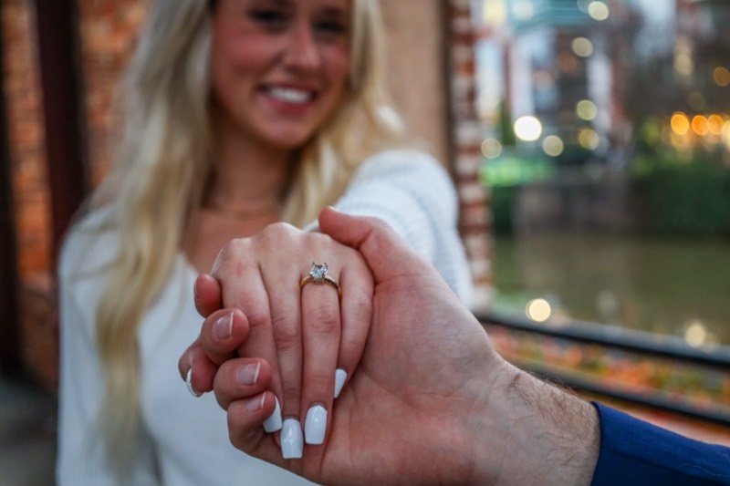Close-up of her new engagement ring in his hand