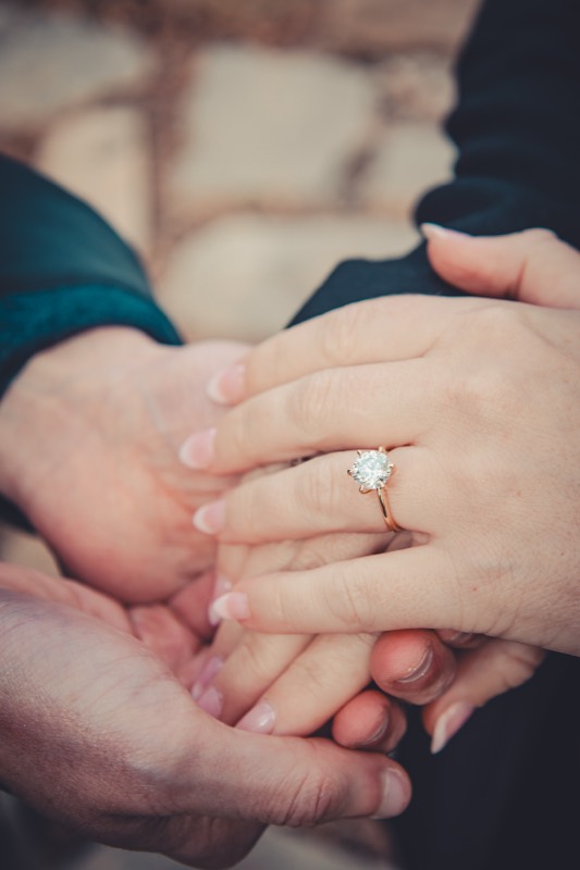 Hands held close with an engagement ring